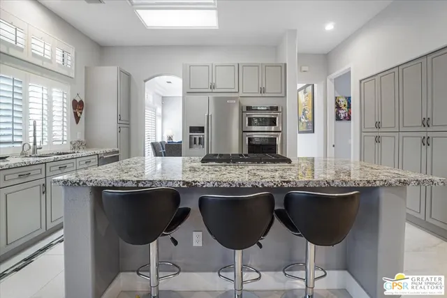 a kitchen with stainless steel appliances granite countertop a sink and stove