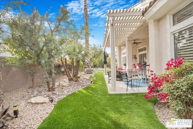 a view of a backyard with plants and brick wall