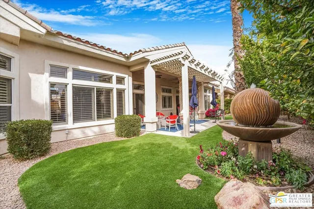 a view of a patio with table and chairs under an umbrella