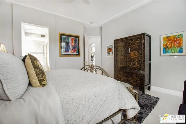 a bedroom with a bed and a painting on the wall