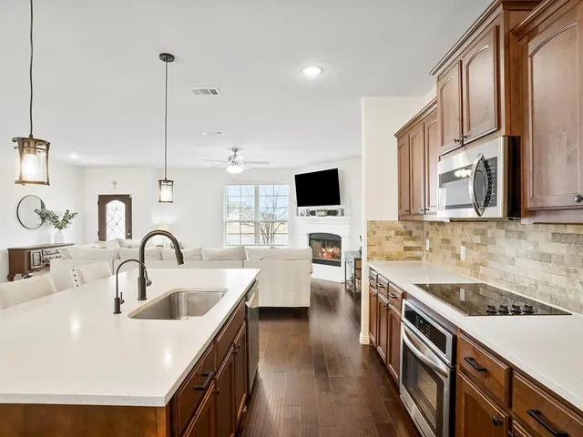a kitchen with a kitchen island a sink appliances and cabinets