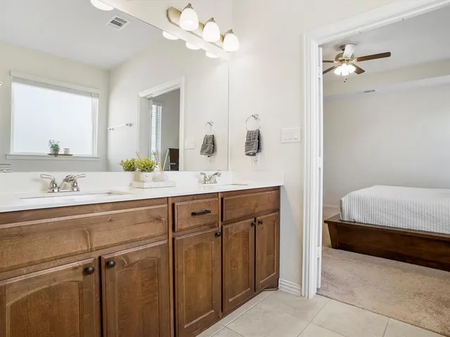 a en suite bathroom with a double vanity sink and a mirror