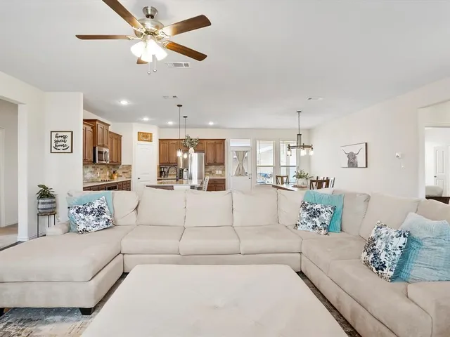 a living room with furniture and kitchen view