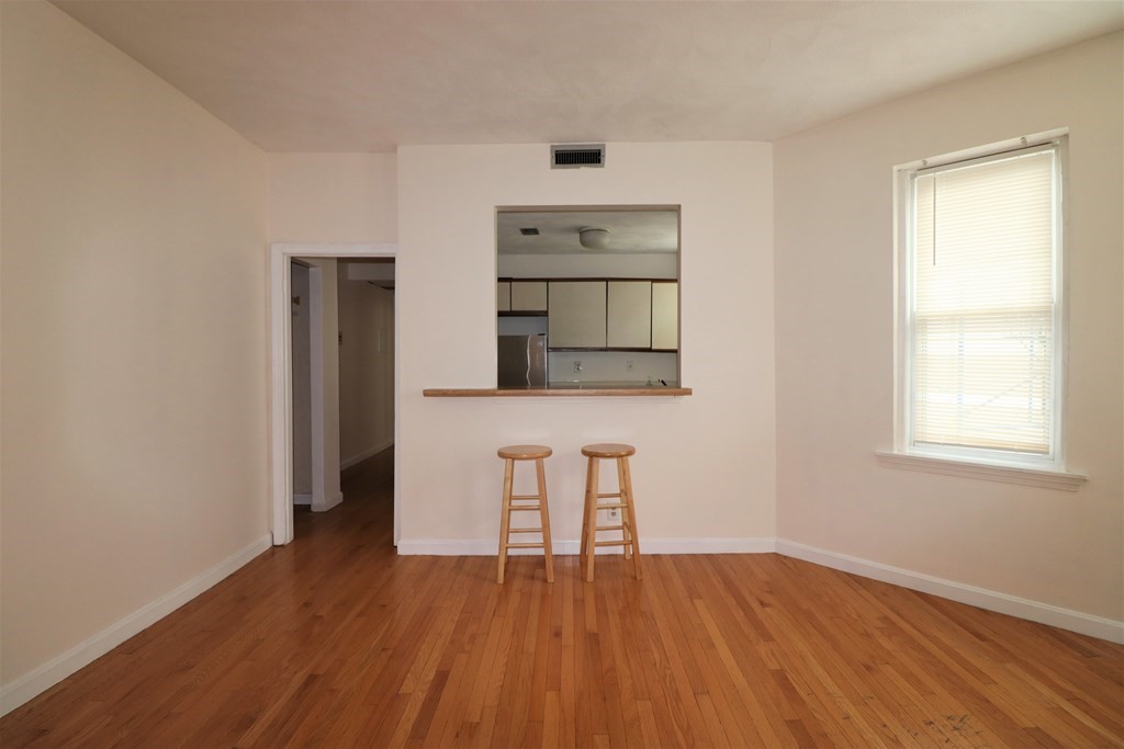 1427 Commonwealth Avenue, Unit 302 Boston, MA 02135 - Photo 3 of 12 an empty room with wooden floor and windows