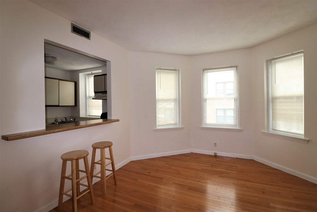 1427 Commonwealth Avenue, Unit 302 Boston, MA 02135 - Photo 4 of 12 a view of a room with wooden floor and windows