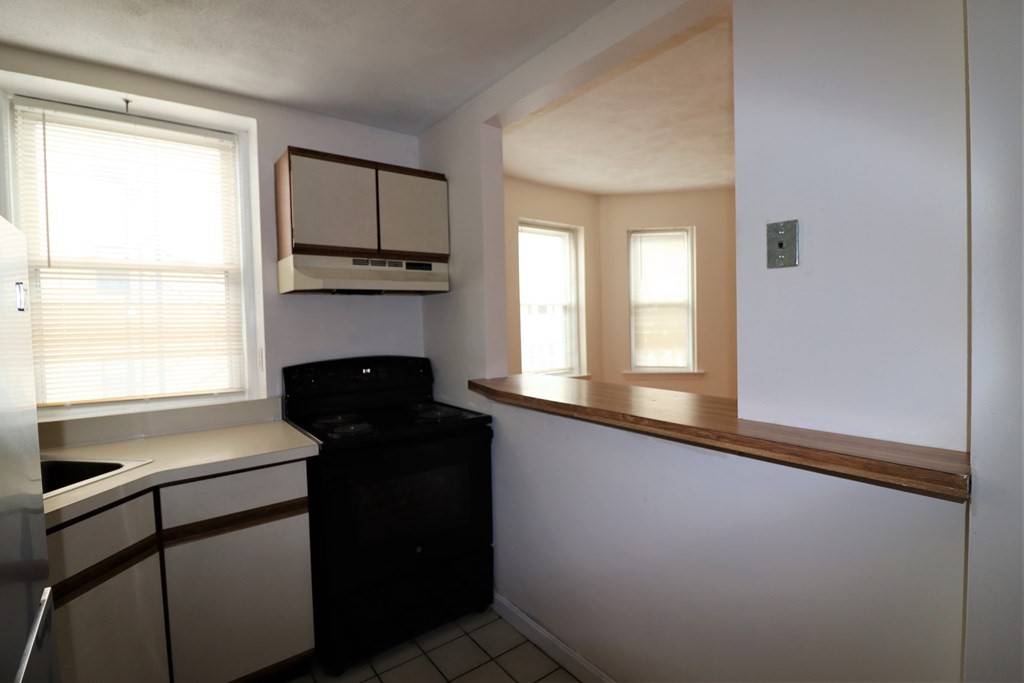 1427 Commonwealth Avenue, Unit 302 Boston, MA 02135 - Photo 10 of 12 a kitchen with a refrigerator and a stove top oven
