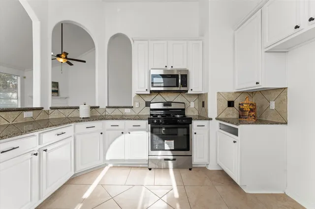 a kitchen with stainless steel appliances granite countertop a refrigerator and a stove top oven