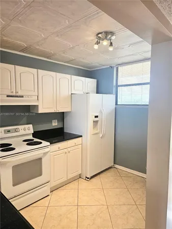 a kitchen with stainless steel appliances granite countertop a refrigerator a sink and a stove