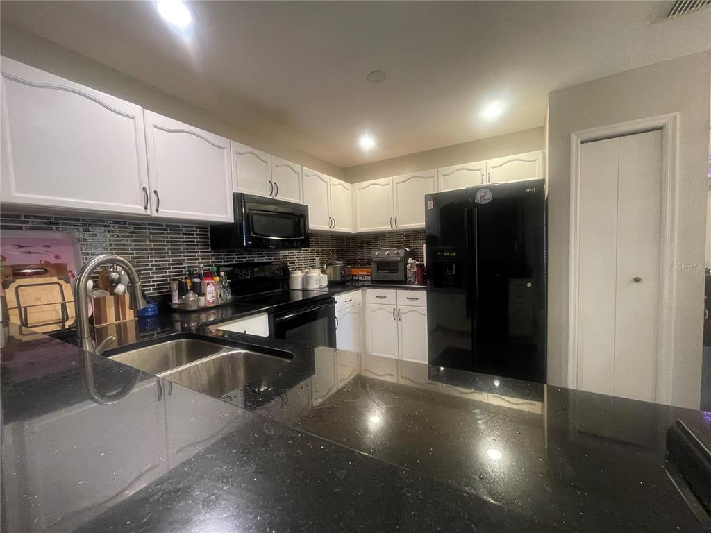 6980 Ulmerton Road, Unit 3G Largo, FL 33771 - Photo 15 of 52 a kitchen with granite countertop a refrigerator and a sink