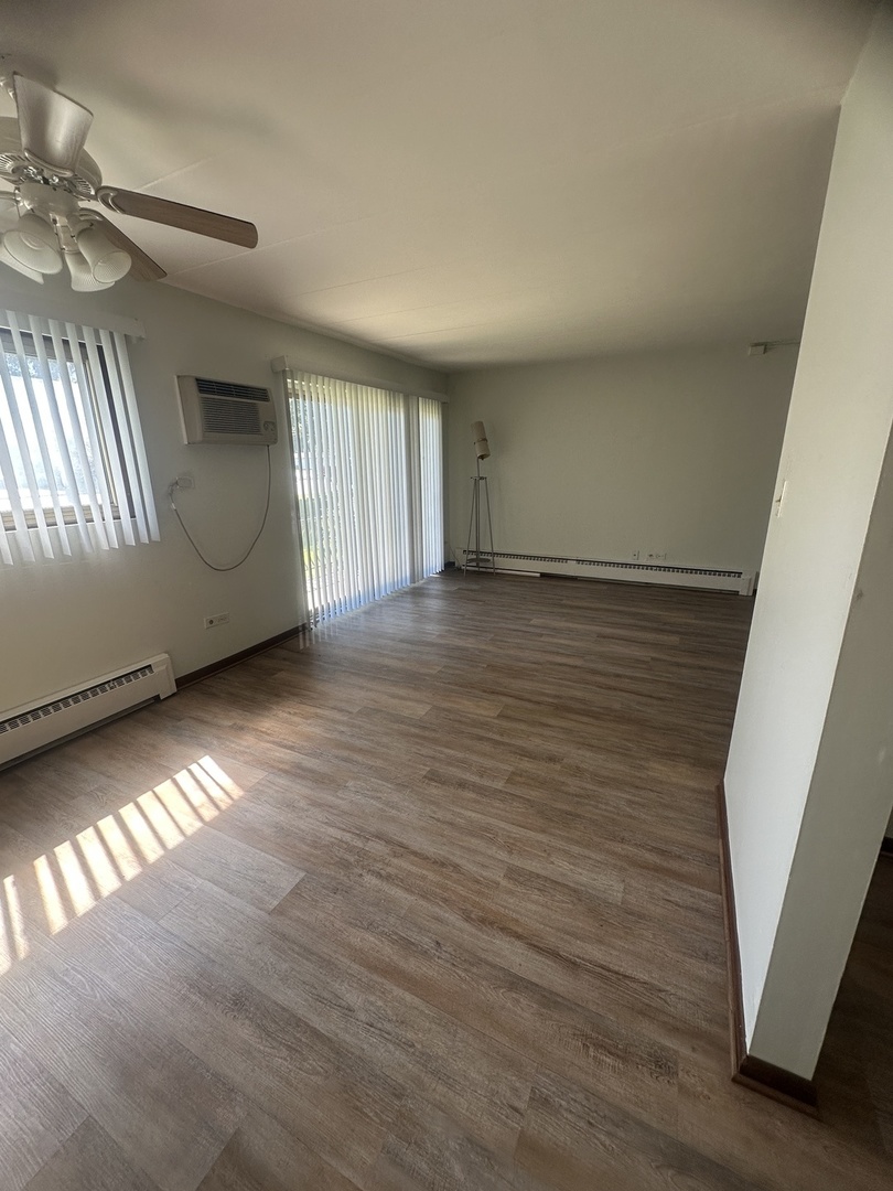 18550 Torrence Avenue, Unit 4 Lansing, IL 60438 - Photo 10 of 14 an empty room with wooden floor and windows