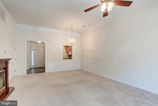 a view of an empty room with a chandelier fan