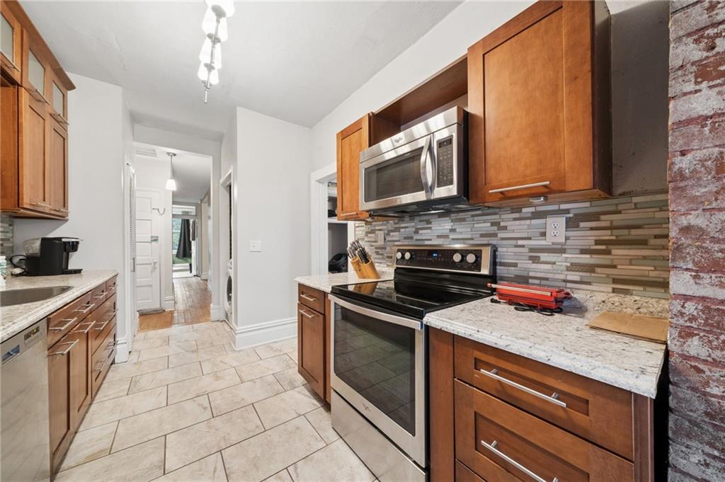1523 Evergreen Road Pittsburgh, PA 15209 - Photo 17 of 35 a kitchen with stainless steel appliances granite countertop a stove a sink and a microwave