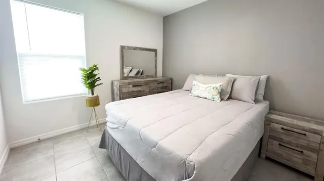 a bedroom with a bed and a potted plant