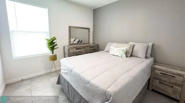 a bedroom with a bed and a potted plant