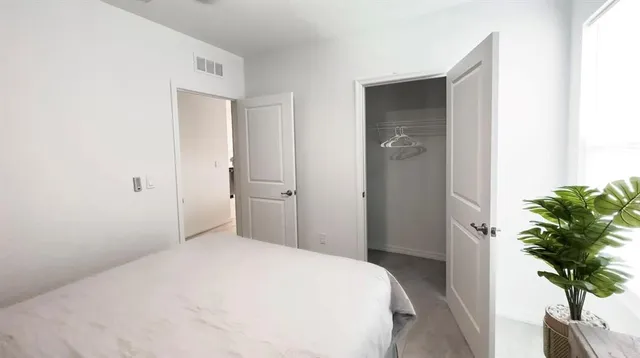 a bedroom with a bed and a potted plant