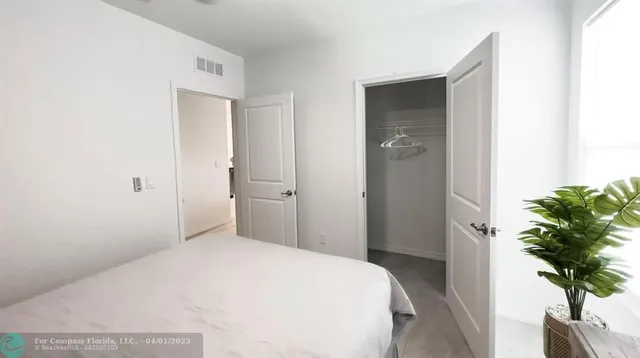 a bedroom with a bed and a potted plant