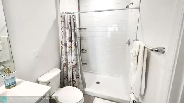 a bathroom with a shower a toilet and a sink