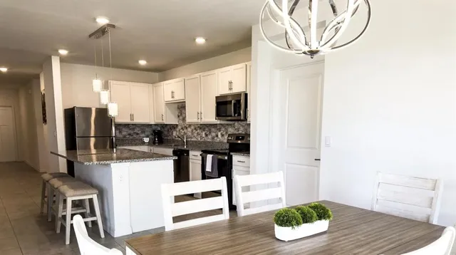 a kitchen with stainless steel appliances kitchen island granite countertop a refrigerator and microwave