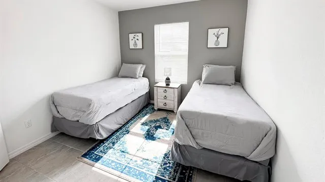 a bed room with two beds and a chair