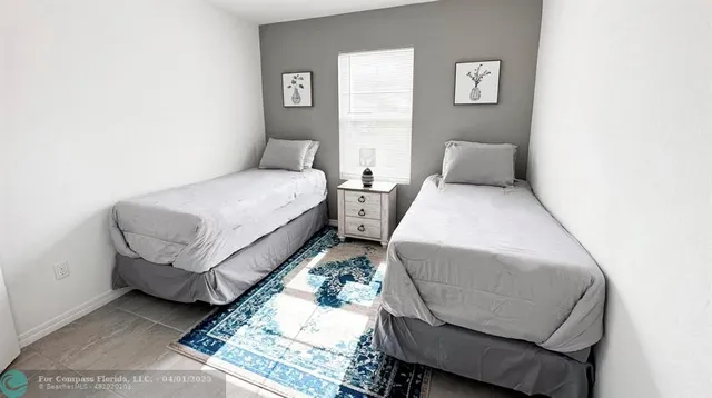 a bed room with two beds and a chair