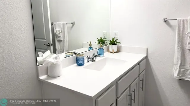 a bathroom with a sink vanity and a mirror