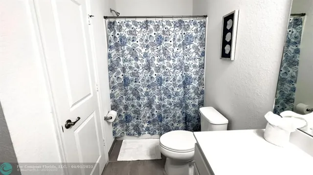 a a bathroom with a toilet and a shower curtain