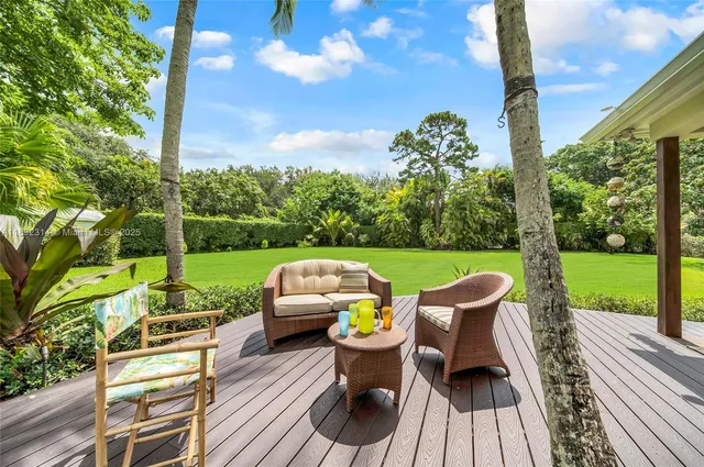 a view of a chairs and table in patio with a yard