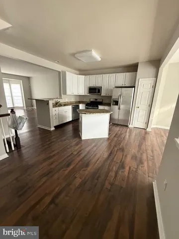 a view of kitchen and hall with wooden floor