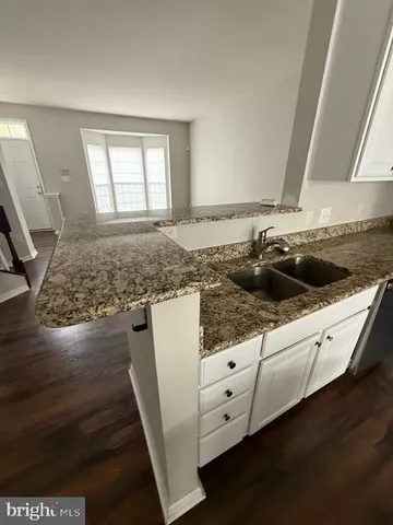a view of empty room with wooden floor and window