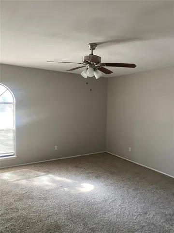 en empty room with windows and fan