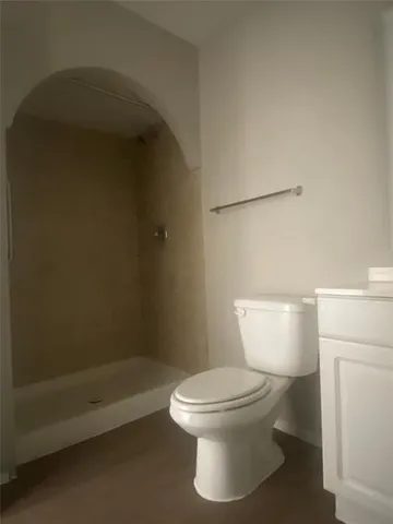 a white toilet sitting next to a bath tub