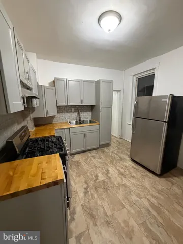 a kitchen with kitchen island a counter top space a sink and a stove top oven
