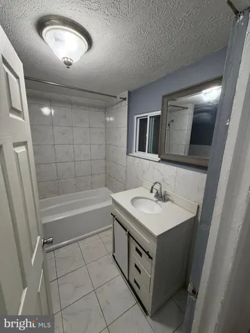 a bathroom with a sink a toilet a mirror and bathtub
