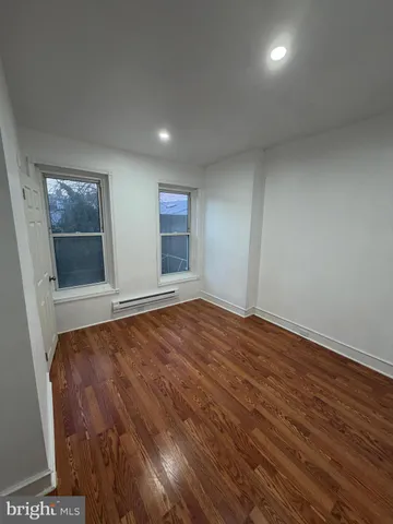 an empty room with wooden floor and window