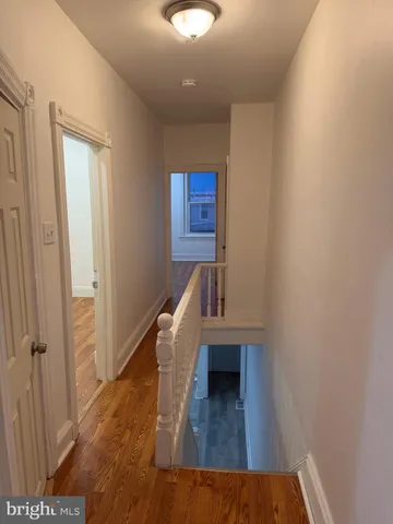 a view of a hallway with wooden floor and staircase
