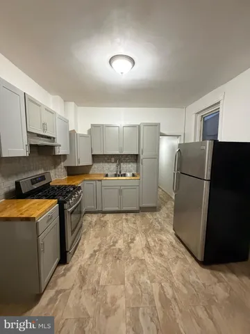 a kitchen with stainless steel appliances granite countertop a refrigerator a stove and a sink