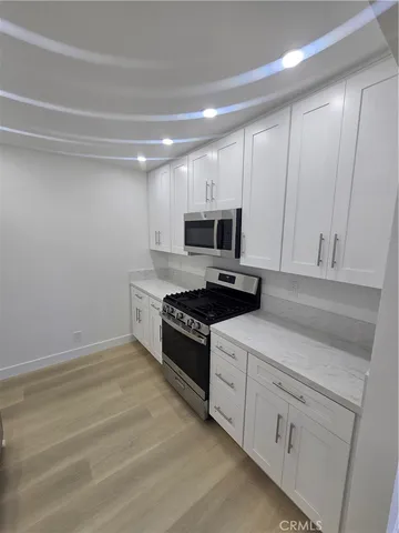 a kitchen with white cabinets and appliances
