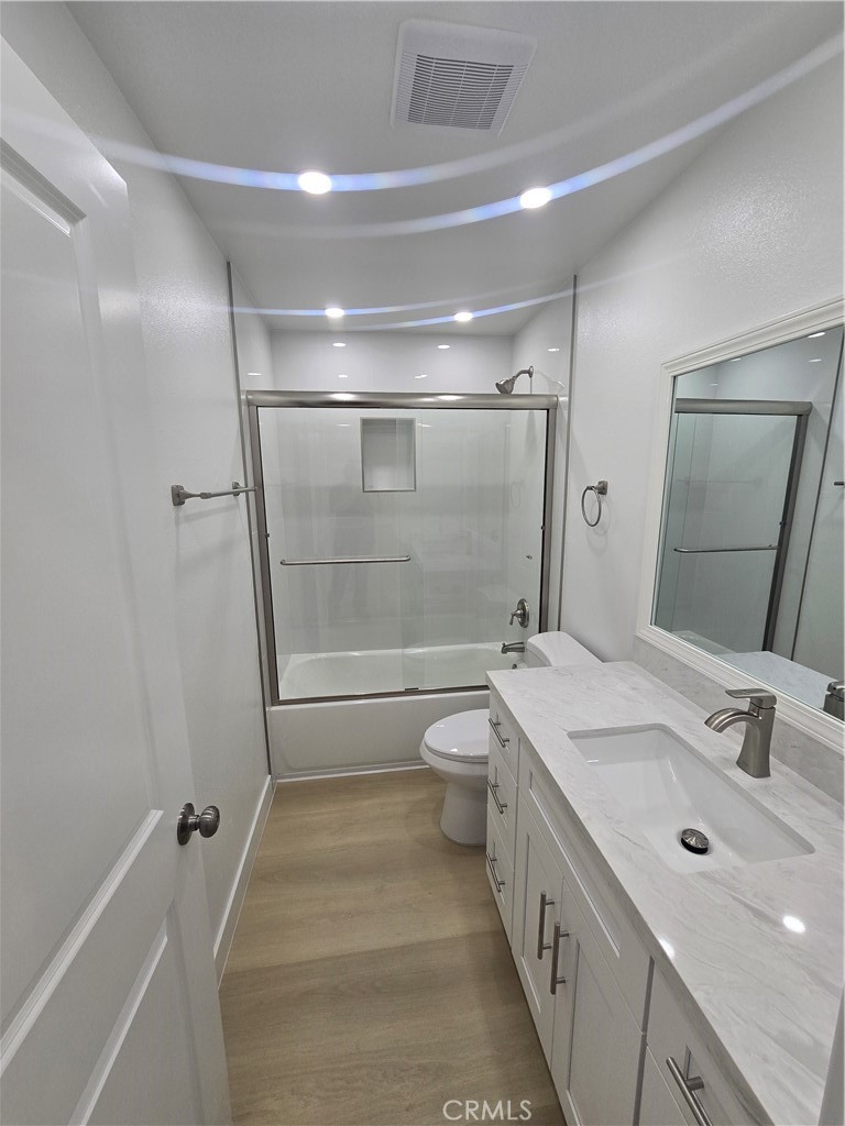 219 15th Street, Unit 12 Huntington Beach, CA 92648 - Photo 8 of 16 a bathroom with a double vanity sink toilet mirror and shower