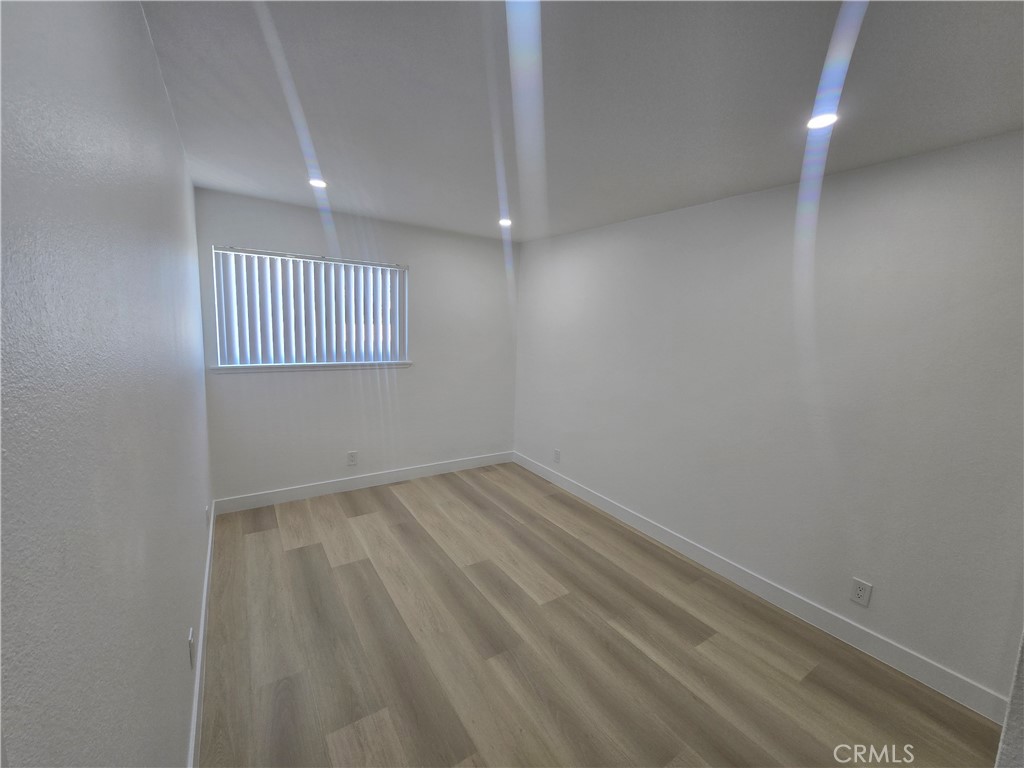 219 15th Street, Unit 12 Huntington Beach, CA 92648 - Photo 10 of 16 a view of an empty room and wooden floor