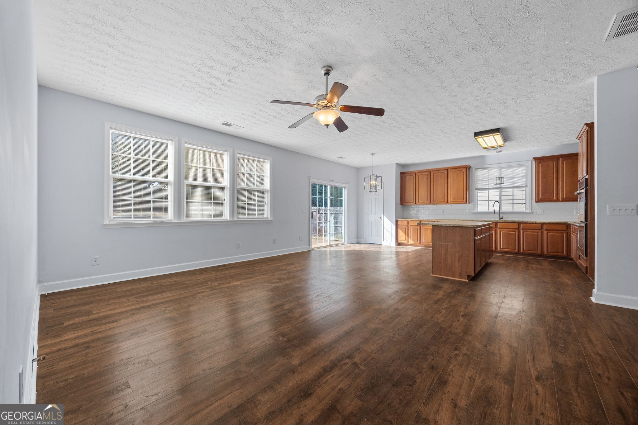 35 Timber Lane Newnan, GA 30265 - Photo 14 of 51 a view of an empty room with a kitchen and wooden floor