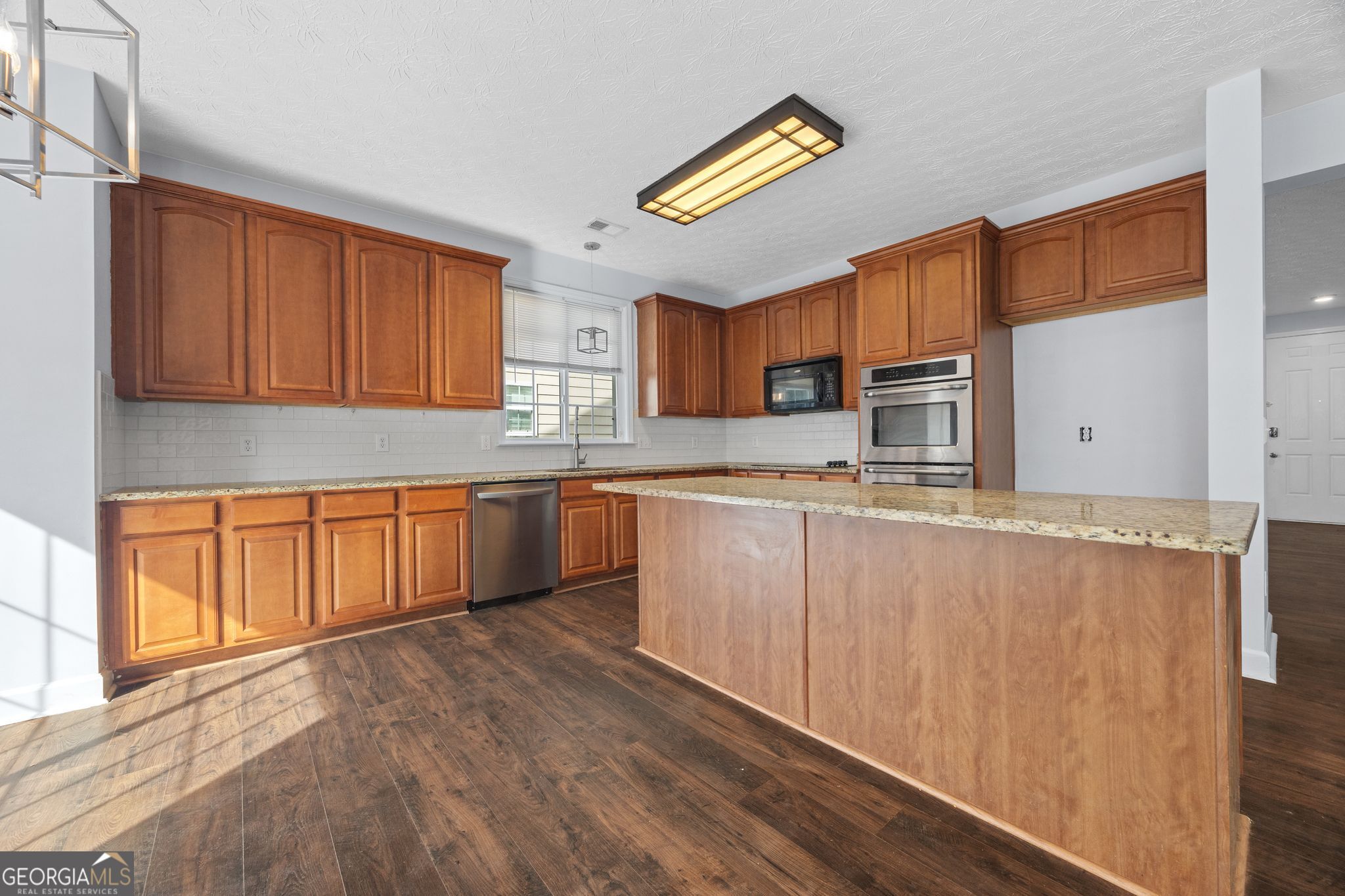 35 Timber Lane Newnan, GA 30265 - Photo 9 of 51 a kitchen with stainless steel appliances granite countertop a stove a sink dishwasher and a refrigerator with wooden cabinets
