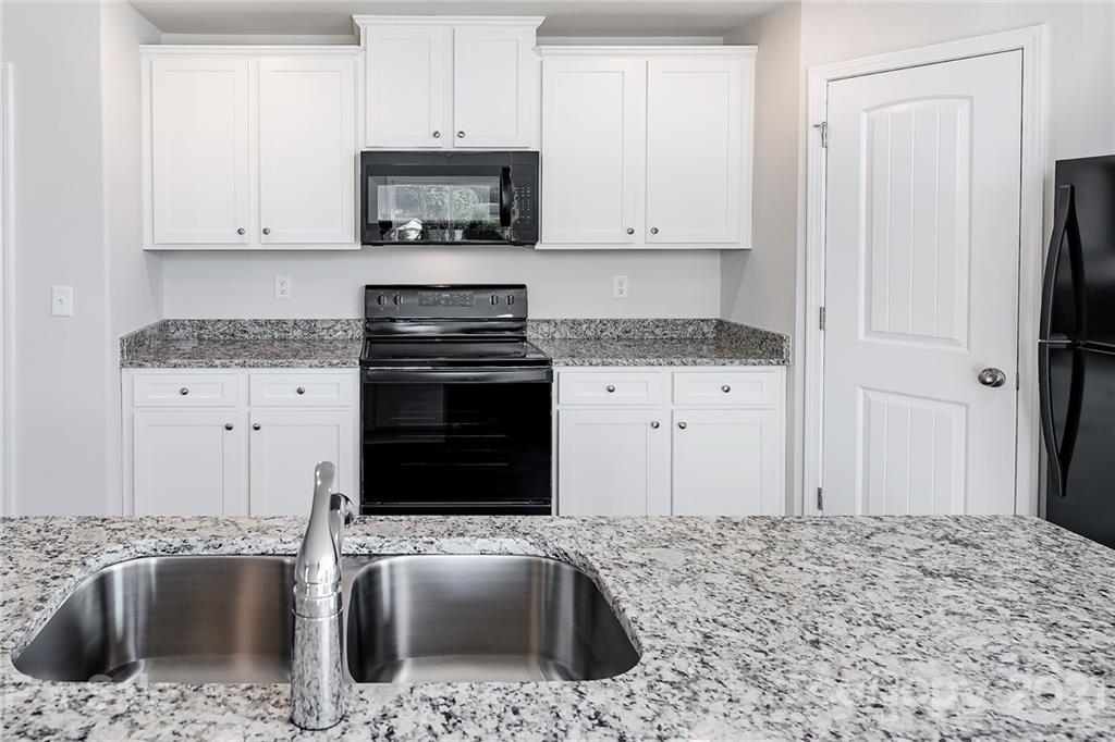 281 Rosedale Street Kings Mountain, NC 28086 - Photo 8 of 19 a kitchen with granite countertop a sink stove and refrigerator