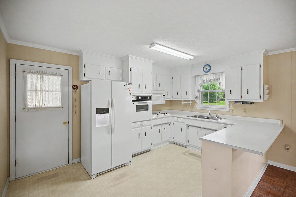 115 Brunson Drive Pickens, SC 29671 - Photo 4 of 29 A traditional kitchen design features abundant white cabinetry and ample counter space for daily culinary tasks.