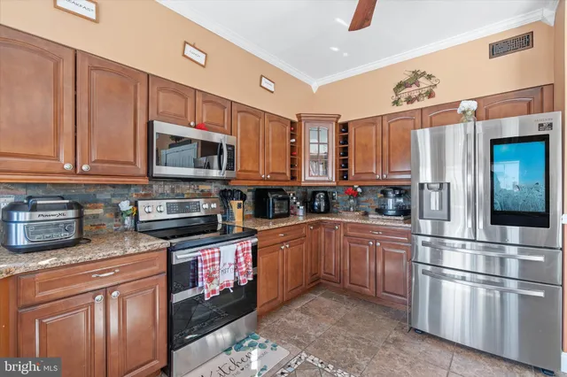 a kitchen with granite countertop a sink cabinets and wooden floor