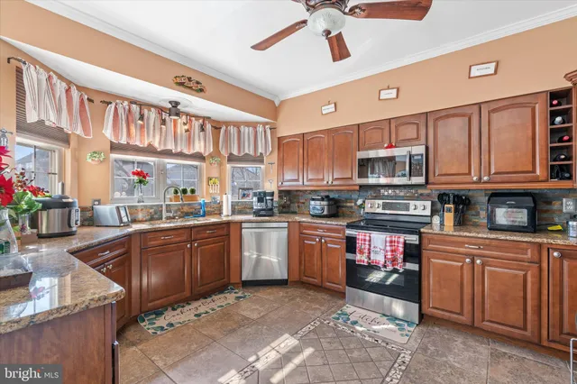 a dining room filled chandelier and wooden furniture