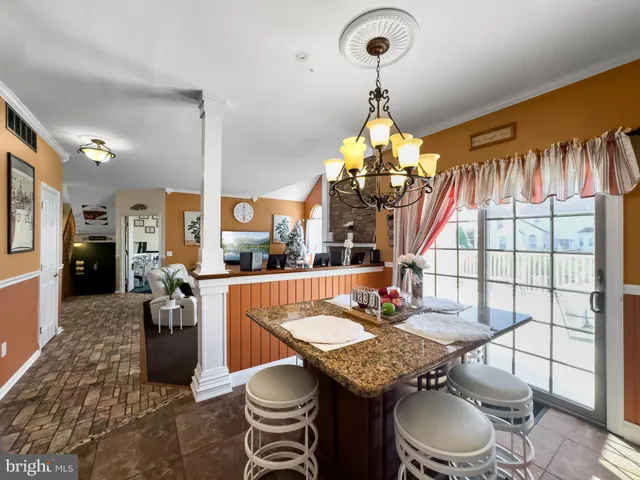 a view of a hallway to a livingroom with wooden floor and furniture