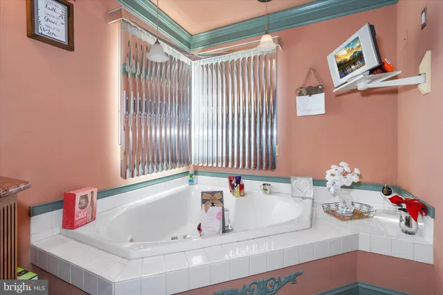 a view of a white house with large windows and wooden fence