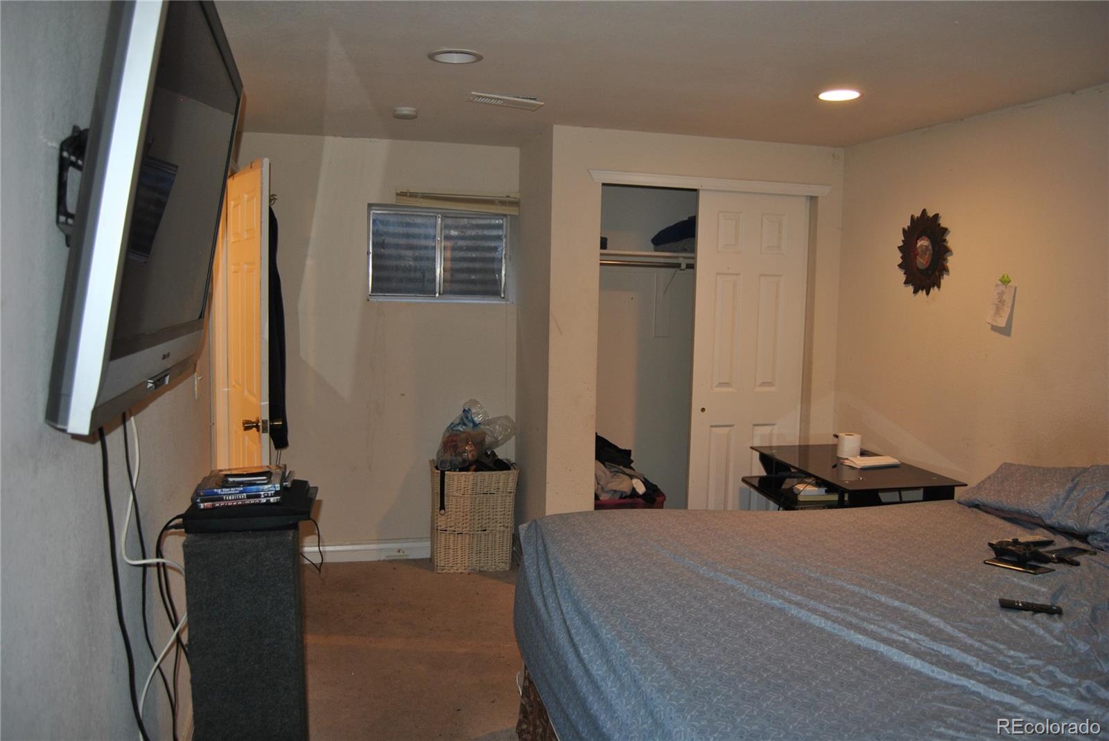 1904 Eagle Street Aurora, CO 80011 - Photo 16 of 27 a bedroom with a bed and a flat tv screen