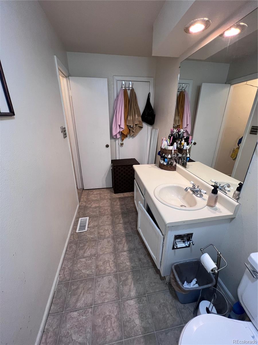 1904 Eagle Street Aurora, CO 80011 - Photo 21 of 27 a bathroom with a sink a mirror and toilet