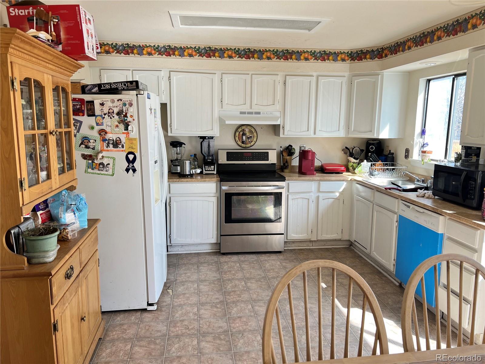 1904 Eagle Street Aurora, CO 80011 - Photo 24 of 27 a kitchen with stainless steel appliances granite countertop a stove a sink and a refrigerator